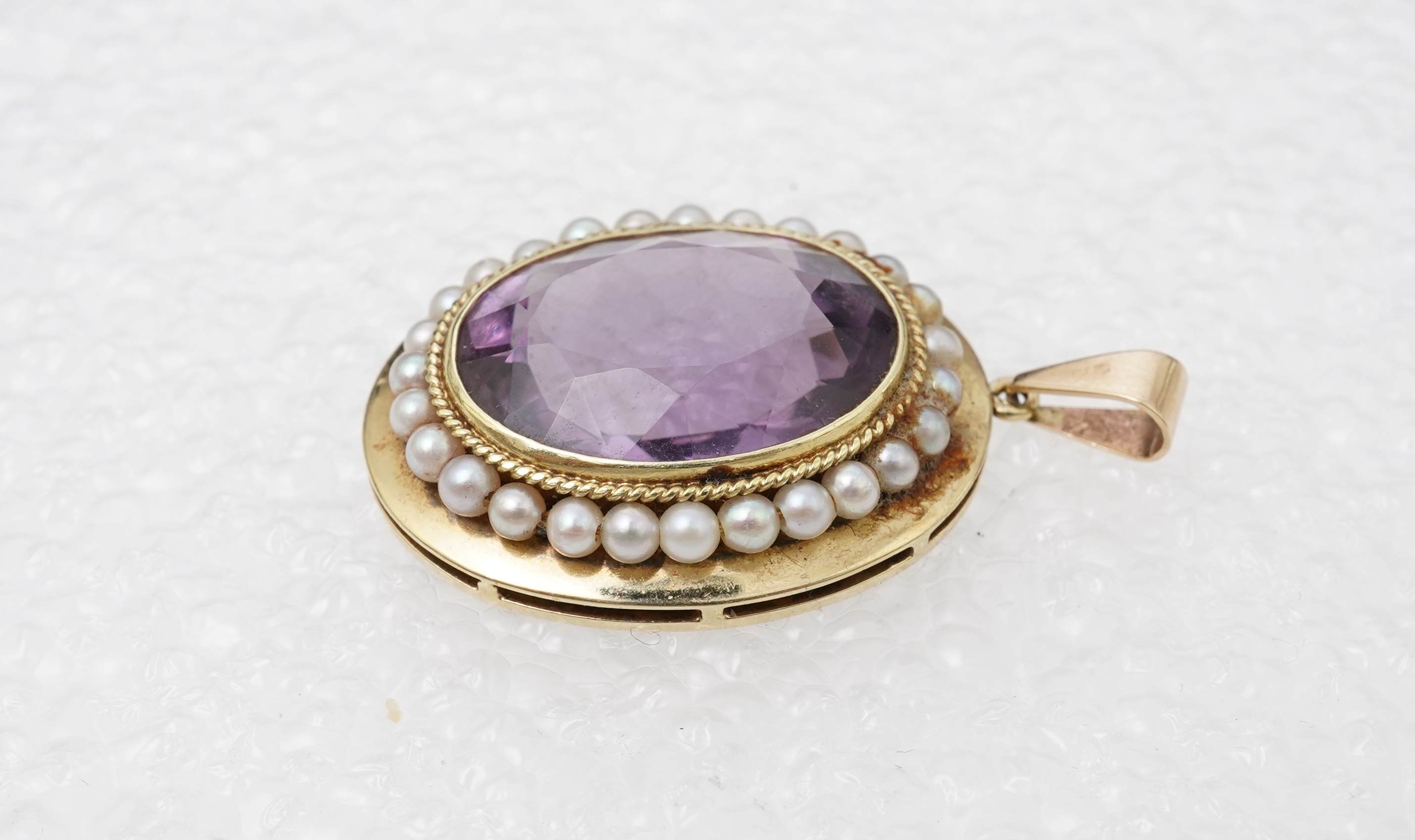 An amethyst ring, necklace and pendant, comprising: an oval amethyst set in a floral gilt silver necklace, length 32cm; an oval amethyst and seed pearl pendant, length 3.7cm; and a ring set with an oval amethyst, mounted